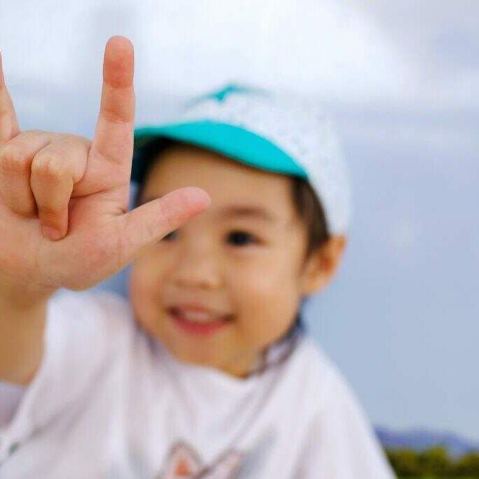 little girl signing "I love you" in sign language